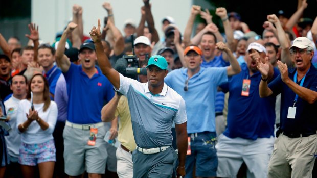 Tiger Woods reacts after chipping in for a birdie on the 10th hole during the first round of the Wyndham Championship at Sedgefield Country Club.