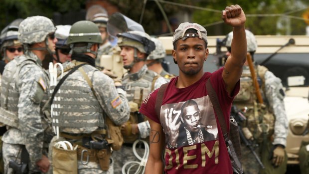 A man celebrates as people gather in the streets of Baltimore following the decision to charge six Baltimore police officers over the death of Freddie Gray.