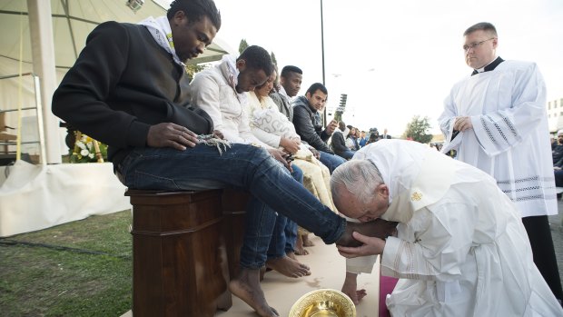 Pope Francis kisses the foot of a man during the foot-washing ritual at the Castelnuovo di Porto refugee centre near Rome on Thursday.
