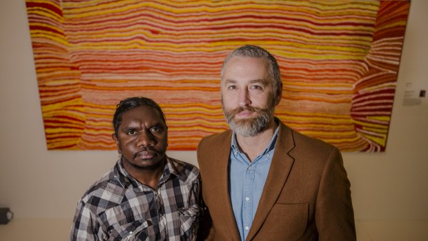 Indigenous artist/film maker Curtis Taylor and National Museum consultant curator Dr John Carty in front of the artwork Kaninjaku 2008, by Kumpaya Giraba, Martumili Artists, which was the inspiration for the exhibition title.