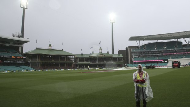 Wet day: A security guard stands on the field at the Sydney Cricket Ground as play is abandoned.