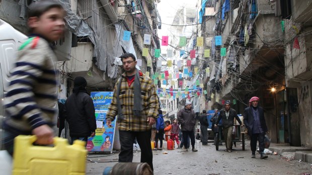 Civilians carry supplies in Aleppo, Syria, this week.