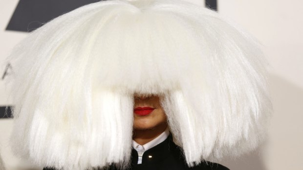 Australian singer Sia arrives at the 57th annual Grammy Awards in her trademark blonde wig.