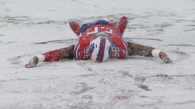 Buffalo Bills' Ryan Davis makes a snow angel on the field before the game.