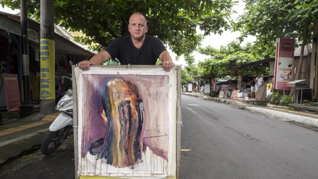 Multimillionaire entrepreneur Shane Yeend holds a painting by Myuran Sukumaran.