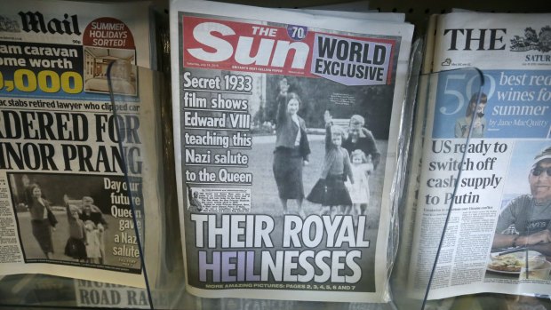 A row of newspapers on display including a paper with a photo of Britain's Queen Elizabeth as a child giving a Nazi salute.