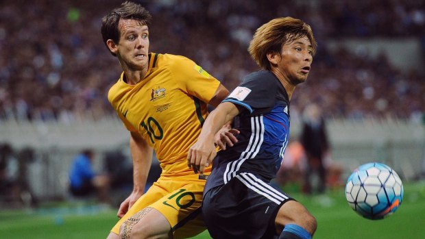 Robbie Kruse competes with Japan's Takashi Inui for the ball.
