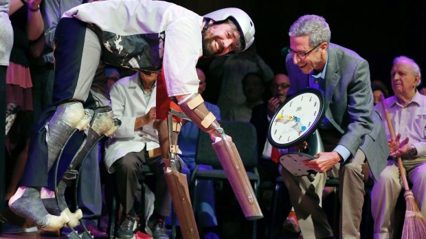 Thomas Thwaites, left, accepts the Ig Nobel prize in biology from Nobel laureate Eric Maskin while wearing his goat exoskeleton.
