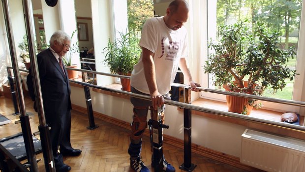 FIRST STEPS: Darek Fidyka walks with the aid of leg-braces and a walking frame at the Akron Neuro-Rehabilitation Center in Wroclaw, Poland.