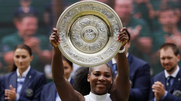 Serena Williams raises the trophy at Wimbledon on Saturday.