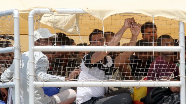 Migrants wait to disembark at Reggio Calabria harbour, Italy, on Friday. 