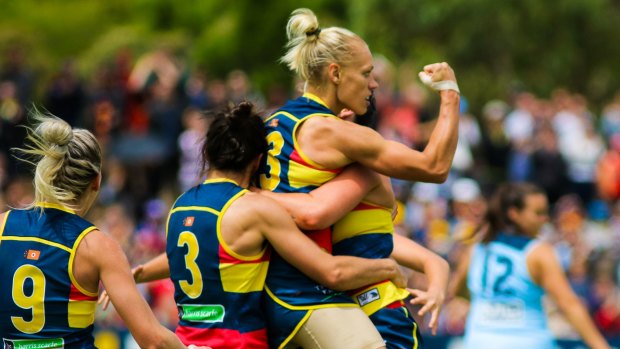 Winning feeling: Erin Phillips and her Adelaide teammates celebrate the top-of-the-table win against Carlton on Sunday. 
