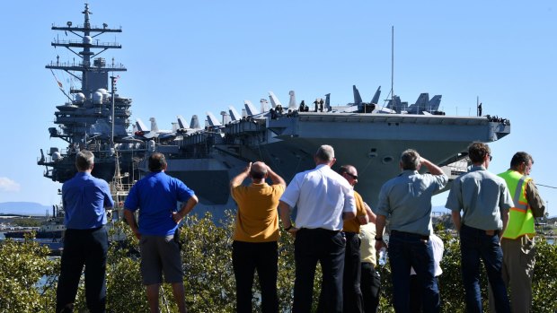 Crowds watch the USS Ronald Reagan dock at the Port of Brisbane on Sunday. 