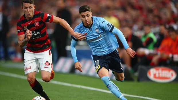 Derby duel:  Scott Neville of the Wanderers and Christopher Naumoff of Sydney FC race for the ball.