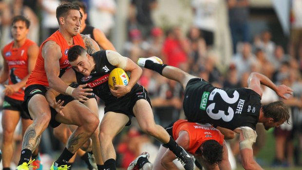Hard at the ball: Jackson Ramsay is tackled in traffic.
