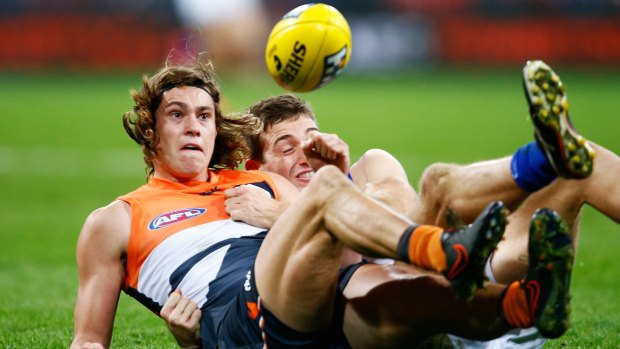 Jack Steele of the Giants is tackled by Shaun Atley of the Kangaroos.