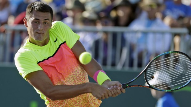 Bernard Tomic returns a shot from Tomas Berdych.