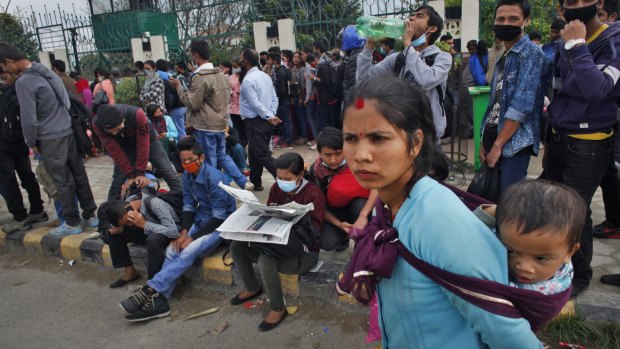 Nepalese people wait in Kathmandu on Wednesday to board buses to their villages.