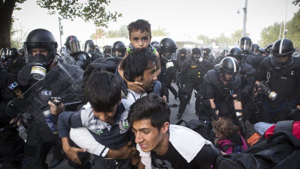 A family flees after Hungarian police responded with force against migrants protesting on the Serbia-Hungary border.