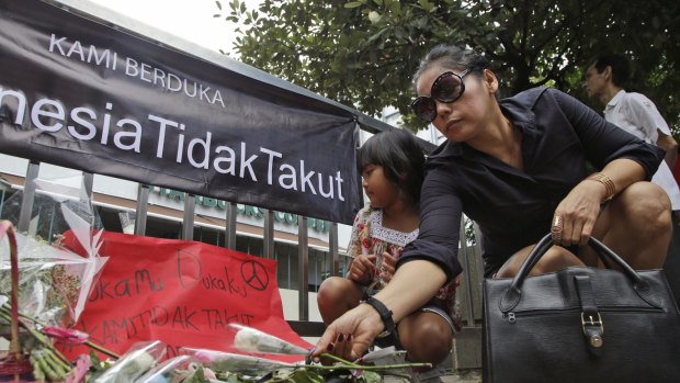 A woman lays flowers outside the Starbucks cafe after January's terrorist attack in Jakarta.