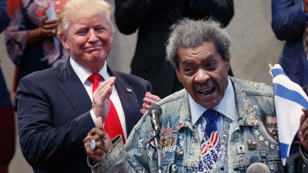 Republican presidential candidate Donald Trump applauds as he is introduced by boxing promoter Don King.