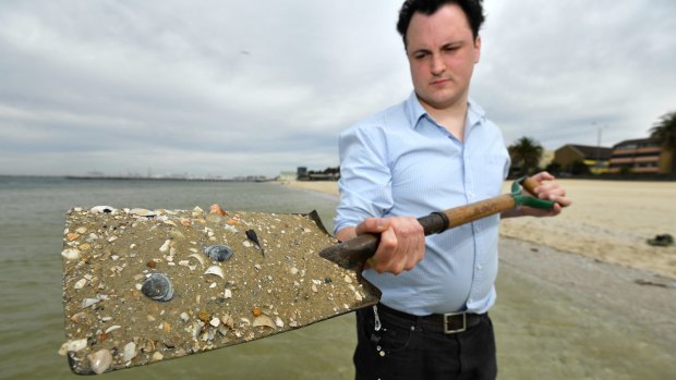 Michael Bourke with sand at Middle Park beach. Each grain of sand would host hundreds of micro-algae.  