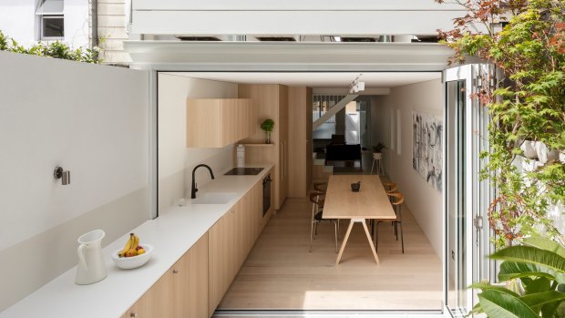 To bring light into this narrow inner-city terrace, the architects extended the kitchen bench into the courtyard using hard-wearing, marine-grade materials.