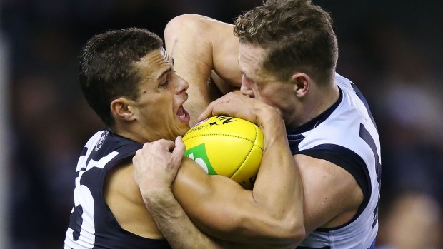 Ed Curnow of the Blues and Joel Selwood of the Cats wrestle for the ball during the round eight match on Friday night.