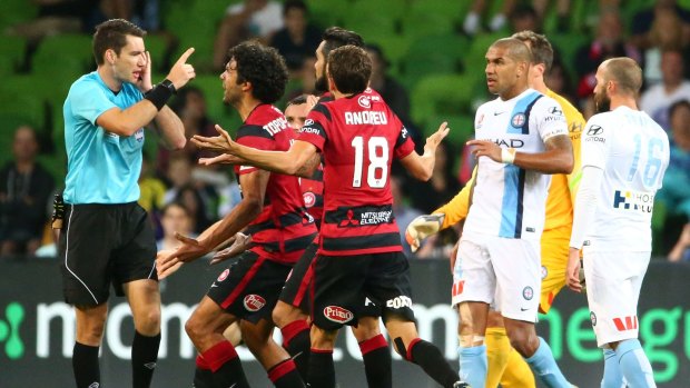 Ref justice: Wanderers players confront referee Jarred Gillett after he ruled that they took a free-kick too quickly.