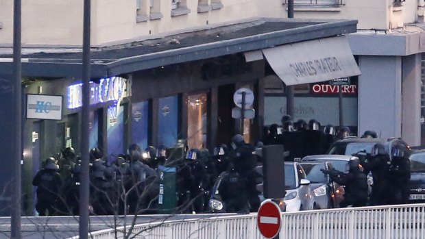 Members of the French police special forces launch the assault at a kosher grocery store in Porte de Vincennes, eastern Paris.