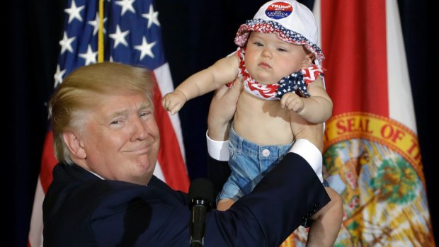 The final stretch: Donald Trump on stage with six-month-old Catalina Larkin in Florida.