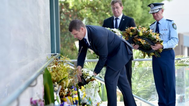 Mr Baird places a floral tribute for NSW Police accountant Curtis Cheng outside Parramatta Police Headquarters.
