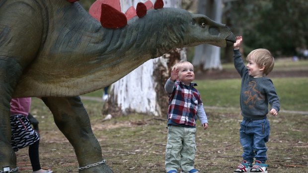 Eli Wilson, 2, and Arlo McClinton, 2, both of Downer, befriend a stegosaurus on the Prehistoric Discovery Trail.