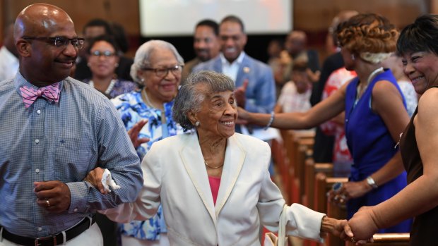 Centenarian Bernice Grimes Underwood  is escorted by her grandson, Tony Grimes,  during her 100th birthday celebration at the Zion Baptist Church on Saturday in Washington, DC. 