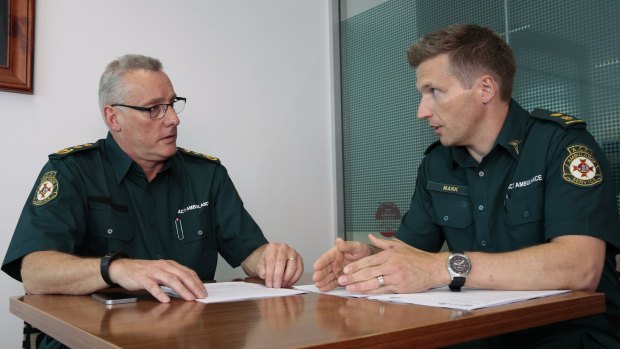 The acting chief officer of the ACT Ambulance Service, Jon Quiggin, left, attends a briefing on the extreme heat plan with capabilities planning operation manager Mark Molloy.