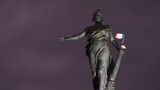 A French national flag and flowers remain hung at the statue named "Le triomphe de la Republique" in Paris.