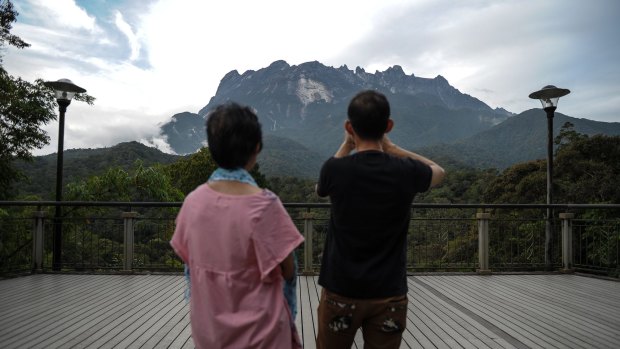 Tourists take photos of Malaysia's Mount Kinabalu on Saturday.