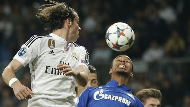 Real Madrid's Cristiano Ronaldo, half hidden rear, heads the ball ahead of teammate Gareth Bale, left, to level scores 1-1.