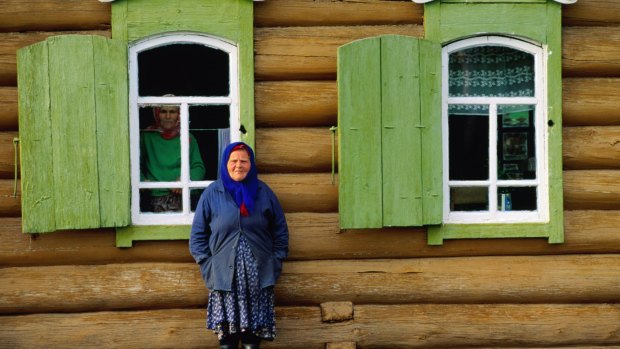 A Woman stands in front of a house in Novosibirsk, Russia.