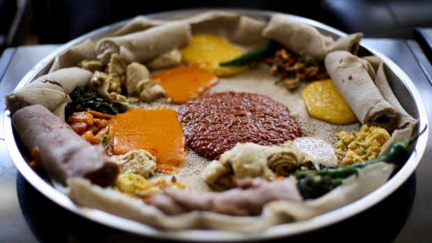 Ethiopian Food: A 'yetsom beyaynetu' is a mix of vegan dishes served on a plate of injera, a pancake like bread made from tef. Dishes include spicy lentil and split pea curries, sides of beans and cabbage and extra injera rolls for eating with your fingers.