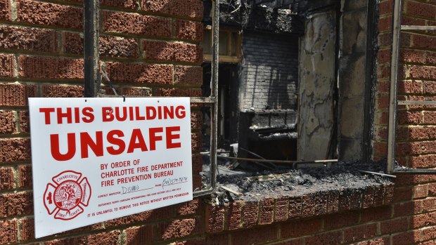 A sign warning the building is unsafe hangs outside the charred remains of Briar Creek Road Baptist Church.