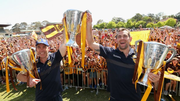 Three-peat: Alastair Clarkson and Luke Hodge with the Hawks' premiership cups after the 2015 grand final.