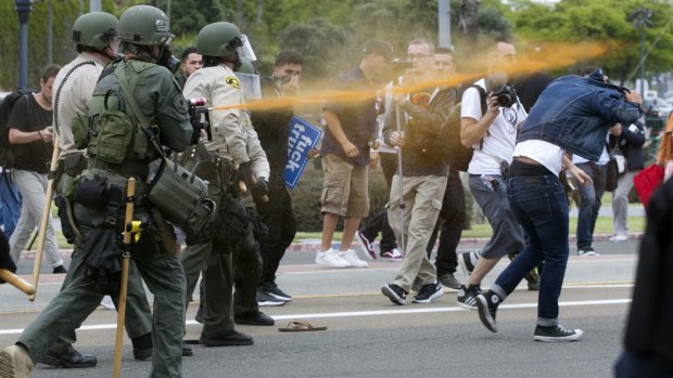 Police pepper spray anti-Trump protesters in San Diego on Friday.