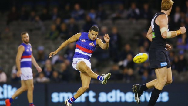 Painful: Jason Johannisen of the Bulldogs kicks, only to end up injuring his hamstring.