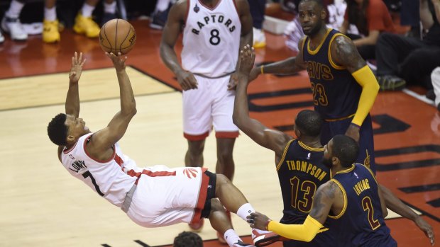 Now that's a fadeaway jumper: Toronto Raptors guard Kyle Lowry shoots as he falls to the floor after being fouled by Cleveland Cavaliers centre Tristan Thompson.