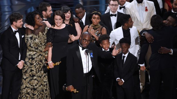 Director Barry Jenkins, foreground centre, and the Moonlight cast accept the award for best picture following the wrong announcement.