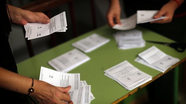 Volunteers, acting as polling station officials, start to count ballots after the polling station closed in the Poble Nou neighbourhood of Barcelona on Sunday.