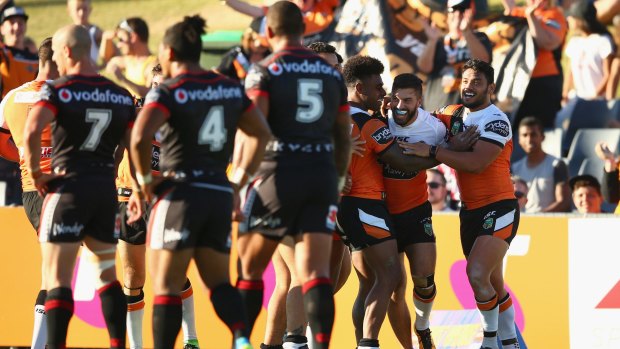 Upset win: James Tedesco celebrates with his teammates after scoring a try during the round one NRL match between the Wests Tigers and the New Zealand Warriors at Campbelltown.