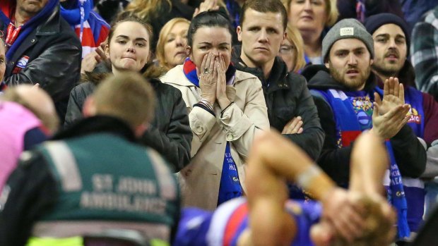 Bulldogs fans look on as Mitch Wallis is stretchered off the field.