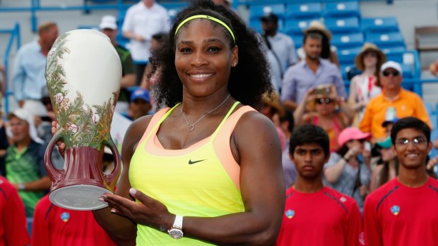 Serena Williams holds up the trophy.